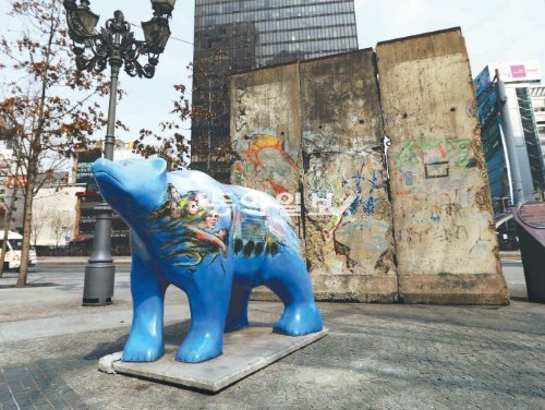 서울 중구 장교동 한화빌딩 앞 베를린 광장에서 포효하는 푸른 곰상. 그 뒤엔 1989년 독일 통일 당시 허물어진 베를린 장벽 일부가 자리 잡고 있다. 장승윤 기자 tomato99@donga.com