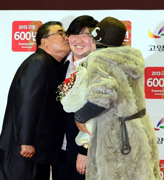 1월 10일 장미란(가운데)의 공식 은퇴식. 두 뺨에 보낸 부모의 키스는 장미란에게 작별과 출발의 의미를 동시에 담고 있었다. 스포츠동아DB