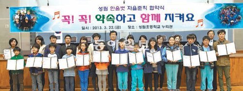 춘천 성림초등학교 5, 6학년 학생과 교사들이 22일 누리관에서 ‘한울벗 자율준칙 협약식’을 마친 뒤 서로 교환한 협약서를 들어 보이고 있다. 1∼4학년은 각 학급에서 진행됐다. 성림초교 제공