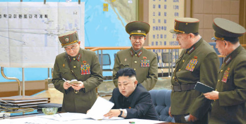 북한군 주요 전력현황 노출… 보안사고? 고의누설? 북한 김정은 노동당 제1비서가 29일 0시 반 군 최고 수뇌부를 긴급 소집해 전략로켓부대에 사격대기 상태에 들어갈 것을 지시했다고 조선중앙통신이 보도했다. 문서를 살펴보는 김 비서 뒤로 왼쪽으론 ‘전략군 미 본토 타격계획’이라는 작전도가, 오른쪽으로는 북한의 해·공군 전력을 정리해놓은 것이 눈에 띈다. 조선중앙통신 연합뉴스