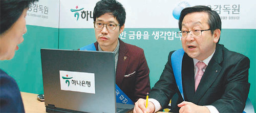 하나은행이 금융감독원과 공동으로 개최한 ‘맞춤형 서민금융상담’ 행사에서 김종준 하나은행장(오른쪽)과 하나은행 홍보대사인 배우 유준상 씨가 고객과 상담하고 있다. 하나은행 제공