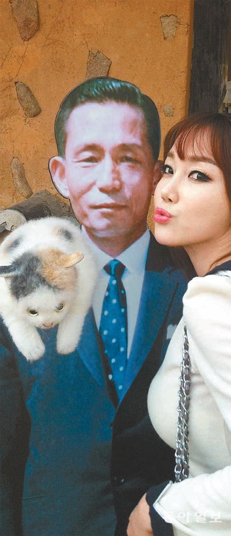 13일 박정희 전 대통령 생가를 방문한 팝아티스트 낸시랭이 자신의 고양이 인형을 박 전 대통령 사진 패널의 어깨에 얹고 볼을 갖다 대는 묘한 포즈를 취하고 있다. 팝아트협동조합 제공