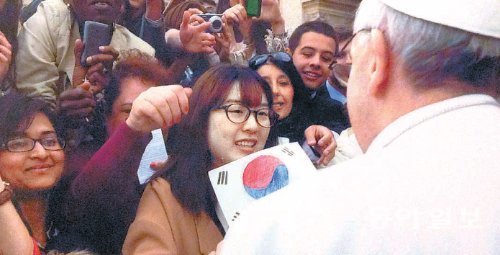 3월 27일 이탈리아 로마 성베드로 광장에서 김헬렌 씨(가운데)가 프란치스코 교황에게 직접 그린 태극기를 들어 보이고 있다. 김 씨는 대성당 앞 계단 바로 오른쪽에 자리를 잡은 덕분에 교황과 20초간 마주할 수 있었다. 김헬렌 씨 제공