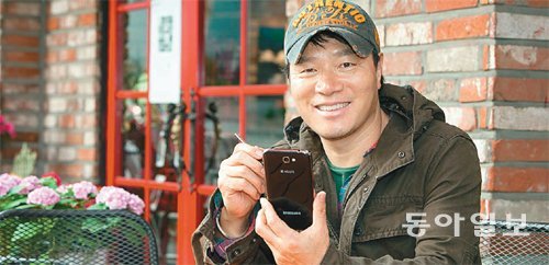 신미식 사진작가가 자신이 운영하는 서울 용산구의 카페 마다가스카르에서 ‘갤럭시 노트Ⅱ’를 쓰고 있다. 삼성전자 제공
