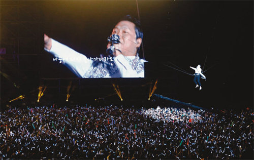 4월 13일 서울 월드컵경기장에서 열린 싸이 단독 콘서트 ‘해프닝’에서 싸이가 와이어를 이용해 공중을 날며 열창하고 있다.