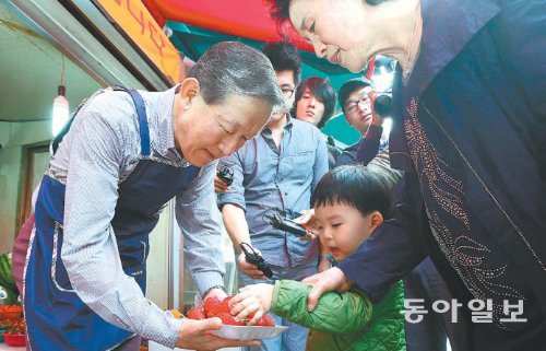 12일 임직원과 함께 ‘시장상인 일일체험’에 나선 허창수 전국경제인연합회 회장이 서울 영등포구 대림동 우리시장에서 손님으로 찾아온 어린이에게 시식용 과일을 권하고 있다. 전경련 제공