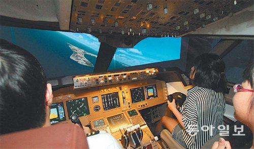 ‘굿게임쇼 코리아 2012’를 찾은 관람객들이 비행기 조종 시뮬레이터를 체험하고 있다. 굿게임쇼 코리아 사무국 제공