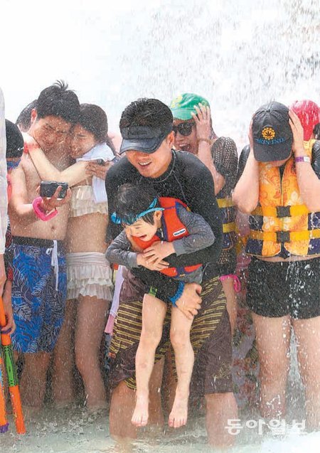 서울 낮 최고기온이 28도까지 오른 26일 경기 용인시 캐리비안베이를 찾은 시민들이 물을 맞으며 더위를 식히고 있다. 용인=김재명 기자 base@donga.com