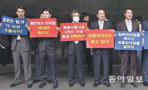 프랜차이즈협회 반발 한국프랜차이즈협회 회원들이 27일 서울 서초구 반포동 서울팔래스호텔 앞에서 동반성장위원회의 대기업·중견기업 음식점 신규 출점 제한 결정에 항의하고 있다. 이날 동반성장위는 수도권 및 광역시의 역세권 반경 100m 이내에서만 대기업·중견기업의 출점을 허용한다고 발표했다. 채널A 화면 촬영