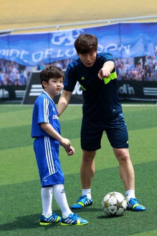 첼시FC 유소년 축구 클리닉에 참석한 송종국 선수가 한 아이를 가르치고 있다.