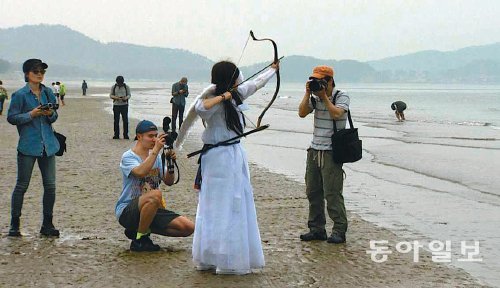 백령도를 평화의 섬으로 만들기 위한 ‘2013 평화미술프로젝트’ 특별기획전에 70여 명의 예술가들이 참가하고 있다. 행위예술가인 이수영 씨가 25일 사곶해수욕장에서 천사 분장으로 퍼포먼스를 펼쳤다. 박희제 기자 min07@donga.com