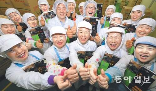 11일 오후 전남 목포시 행남식품 공장 제품창고에 모인 행남식품 임직원들이 자체 브랜드 ‘참 맛 좋은 김’을 들어 보이고 있다. 행남식품 공장에서 생산된 대부분의 제품은 풀무원 상표를 달고 나오지만 6∼7%는 자체 브랜드로 생산한다. 수량이 워낙 적어 소매점에선 찾아보기 어렵지만 행남식품의 자랑거리 중 하나다. 목포=박영철 기자 skyblue@donga.com