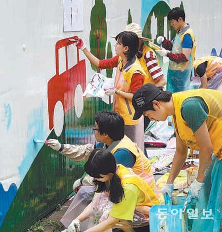 이마트 ‘희망마을 프로젝트’ 참가자들이 19일 오후 서울 성동구 사근초등학교 인근 담벼락에 그림을 그리고 있다. 전영한 기자 scoopjyh@donga.com