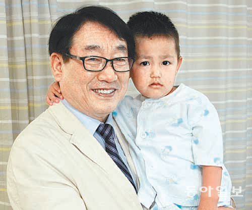 몽골에서 온 부머딘 볼더린 군(오른쪽)이 건강을 되찾은 뒤 주치의인 서울성모병원 소아외과 이명덕 교수에게 안겨 기념사진을 찍고 있다. 서울성모병원 제공