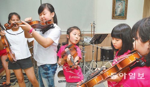 18일 탈북 청소년 대안학교인 서울 두리하나 국제학교에서 진행된 바이올린 수업에서 학생들이 새로 받은 바이올린을 조율하기 위해 줄서 있다. 자신의 악기가 신기한지 바이올린을 살펴보거나 만져보고 있다. 변영욱 기자 cut@donga.com