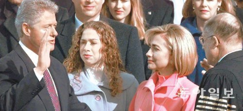 1997년 1월 20일(현지 시간) 미국 워싱턴 의회의사당 광장에서 빌 클린턴 대통령(왼쪽)이 2기 취임선서를 하는 모습을 딸 첼시(왼쪽에서 두 번째)와 부인 힐러리(왼쪽에서 세 번째)가 지켜보고 있다. 동아일보DB