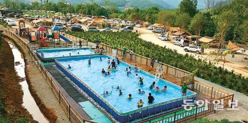 최근 다양한 볼거리 즐길거
리 먹거리가 있는 이색 캠핑
장이 인기를 끌고 있다. 사
진은 경기 연천군 ‘땅에미
소’ 오토캠핑장 내에 설치된
야외수영장에서 캠핑객들이
물놀이를 즐기고 있다.
땅에미소캠핑장 제공