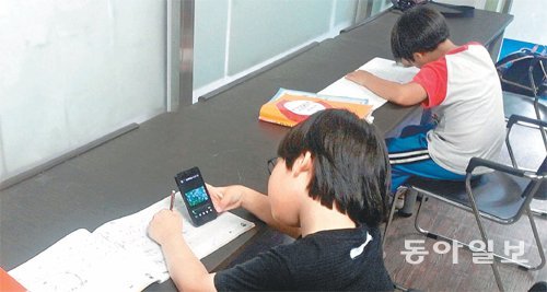 최근 왜곡된 인터넷 문화에 노출되는 초등생이 늘고 있다. 사진은 20일 경기의 한 학원에서 공부하던 한 초등생이 스마트폰으로 인터넷 커뮤니티 활동을 하는 모습.