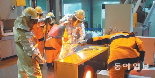 포스코 광양기술연구소 실험동에서 포스코와 동도바잘트산업 공동연구팀 팀원들이 슬래그를 녹여 만든 액체를 성형틀에 붓고 있다. 포스코 제공