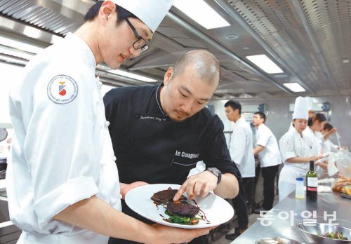 서문용욱 셰프(오른쪽)가 서울 동빙고동 SK해피쿠킹스쿨에서 전문 조리사 교육을 받는 양준석 씨가 만든 음식을 살펴보며 조언을 하고 있다. 서 셰프를 비롯한 유명 레스토랑 셰프 8명은 SK행복나눔재단과 업무협약을 맺고 이곳 학생들에게 인턴십과 취업 연계 지원 등을 제공할 예정이다. SK행복나눔재단 제공