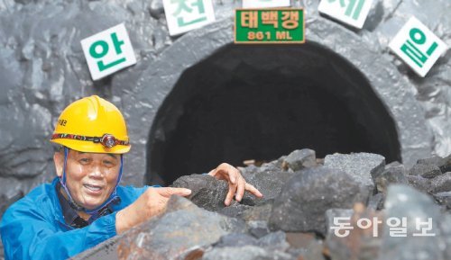 강원 태백시 석탄박물관에서 해설사로 일하는 남효준 명장이 박물관의 모형 갱도 앞에서 석탄을 들어 보이고 있다. 29년간 대한석탄공사 장성광업소에서 근무했던 남 씨는 박물관을 찾는 관람객들에게 광산에서 몸소 겪은 당시의 이야기를 전해주는 걸 광원으로서의 ‘마지막 소명’으로 여기고 있다. 태백=김재명 기자 base@donga.com