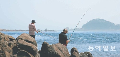 소야도 갯바위 낚시 포인트에서 낚시꾼 2명이 릴낚시를 하고 있다. 이 해안가는 하루 2차례 바다 갈림길 현상이 일어나 앞에 보이는 가섬, 간데섬, 물푸레섬을 걸어서 건너갈 수 있다. 인천 옹진군 제공