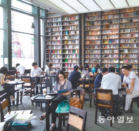 출판사 문학동네가 서울 마포구 동교동에서 운영하는 북카페 ‘카페 꼼마’ 2호점에서 손님들이 책을 읽으며 커피를 마시고 있다. 카페 꼼마는 진열된 책 5000여 권을 저렴한 가격에 판매하고 있다. 문학동네 제공