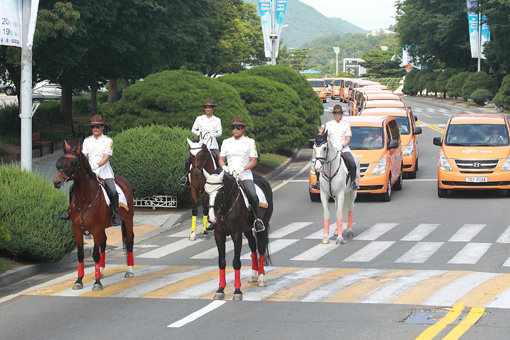 한국마사회 기마경찰대가 11일 서울경마공원에서 열린 ‘사랑의 황금마차’ 전달식에서 복지시설에 제공될 승합차들과 함께 기념 퍼레이드를 펼치고 있다. 사진제공｜한국마사회