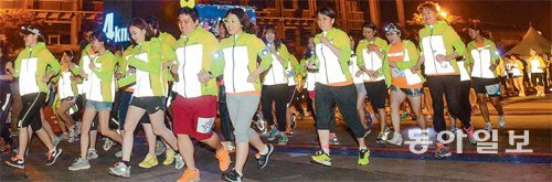 지난달 5일 서울 중구 장충동 해오름극장 앞에서 열린 ‘미드나잇 챌린지 트레킹’ 행사에서 참가자들이 출발선을 넘어 달리고 있다. 이젠벅 제공