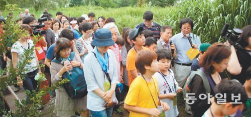 20일 오후 6시 서울 마포구 상암동 한강난지공원에서 ‘한강스토리텔링 투어’에 참가한 시민 100여 명이 ‘새박사’ 윤무부 경희대 명예교수에게서 한강의 새에 대한 설명을 듣고 있다. 조영달 기자 dalsarang@donga.com