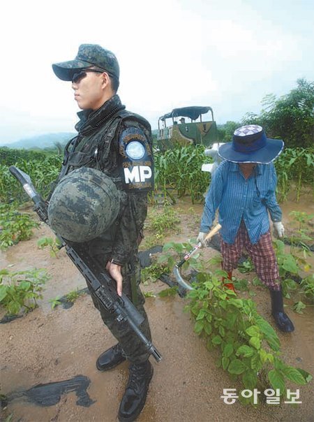 SA 경비대대 대원들이 비무장지대(DMZ) 내 대성동 마을 인근 밭에서 일을 하는 주민을 경호하고 있다. 판문점=신원건 기자 laputa@donga.com