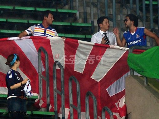28일 한일전이 열린 잠실주경기장에서 일본 응원단이 욱일승천기를 들고 응원하자 축구관계자가 제지하고 있다. 김민성 기자 marineboy@donga.com 트위터 @bluemarine007