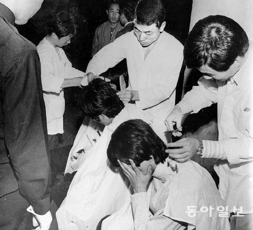 장발족 단속에 걸린 남자들이 경찰서에서 바리캉으로 머리를 잘리고 있다. 동아일보DB