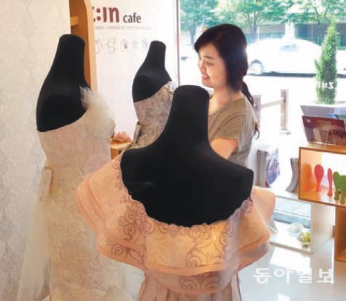 6일 부산 해운대구 우동에 있는 LG하우시스 부산전시장에서 한 여성 직원이 LG하우시스의 ‘베라 왕 벽지’로 만든 웨딩드레스를 살펴보고 있다. LG하우시스 제공