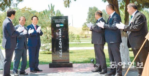 김관용 경북도지사와 김상준 경주시 부시장(기념비 왼쪽부터)이 최근 우즈베키스탄 사마르칸트 시 아프라시아브 박물관에서 사마르칸트 시 관계자들과 실크로드 우호협력 기념비를 세운 뒤 박수를 치고 있다. 경북도 제공