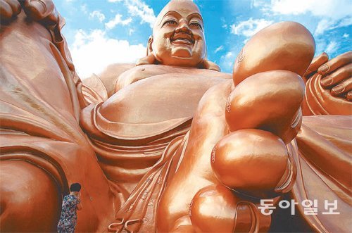 펑화에 실존했던 당나라 승려 포대화상을 모델로 조성한 쉐더우사(寺)의 38m 높이 ‘인간미륵’ 불상. 한 불자가 그 아래서 불공을 드리고 있는데 이 발가락에 영험이 있다고 믿고 있다.