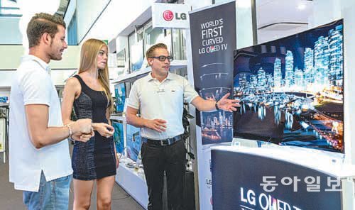최근 독일 프랑크푸르트의 가전매장 ‘하이파이 프로피스’에서 직원이 소비자들에게 LG전자의 곡면 유기발광다이오드(OLED) TV를 소개하고 있다. LG전자는 28일(현지 시간) 이 매장에서 곡면 OLED TV의 공식 출시 행사를 연다. LG전자 제공