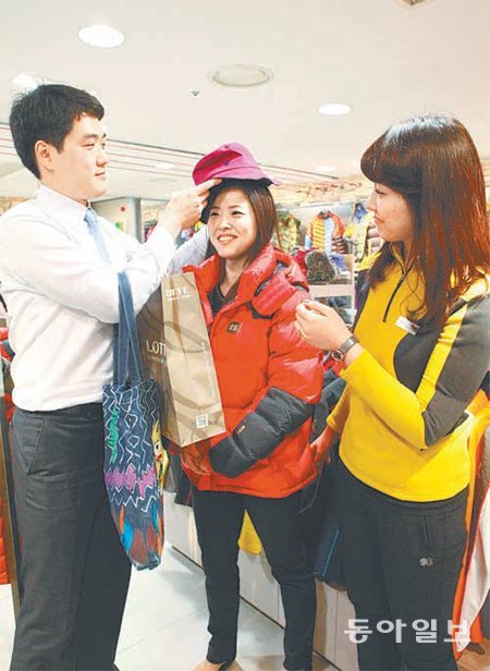 25일 서울 중구 소공동 롯데백화점 본점을 찾은 여성고객이 신상품 다운재킷을 입어보고 있다. 롯데백화점 제공