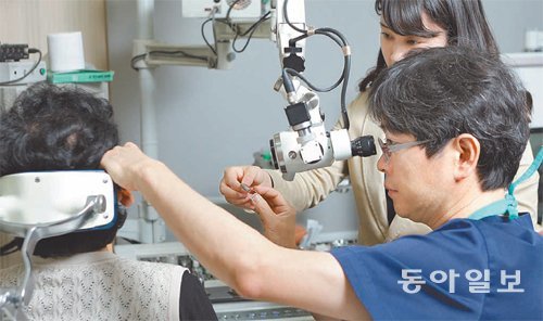 김성근이비인후과·서울청각클리닉 원장(오른쪽)이 환자의 오른쪽 귀를 진료하고 있다. 김성근이비인후과 제공