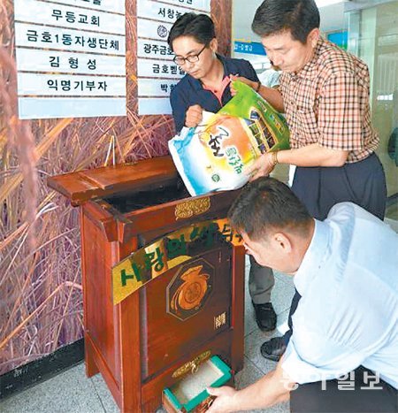 26일 광주 서구 금호1동 주민센터 직원들이 각계에서 보내준 쌀을 ‘사랑의 쌀뒤주’에 채우고 있다. 2006년 1월 설치된 사랑의 쌀뒤주는 지금까지 2만1782명이 이용한 것으로 집계됐다. 광주일보 제공