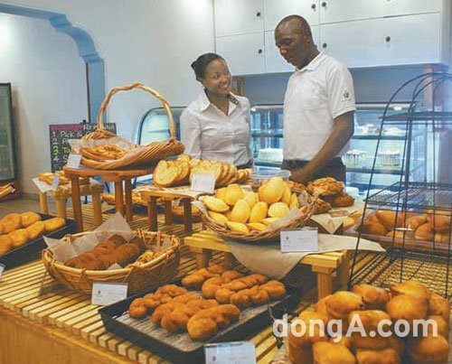 르완다의 수도 키갈리에 있는 빵집 ‘라즈만나’에서 현지 직원들이 진열대의 빵을 정리하고 있다. 키갈리=이정은 기자 lightlee@donga.com