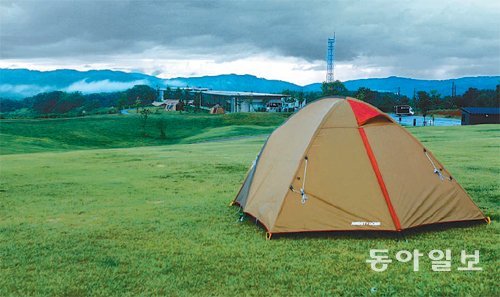 해발 190m의 산중턱 초원구릉의 스노피크 캠핑장. 텐트 뒤로 보이는 건물이 스노피크 헤드쿼터(본사)다.