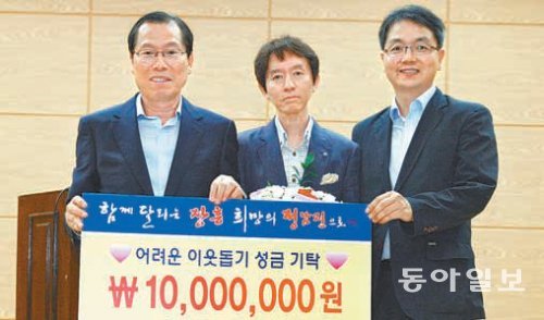 김융기 원장(가운데)이 3일 이명흠 장흥군수(왼쪽)에게 사랑의 성금 1000만 원을 기탁하고 있다. 장흥군 제공