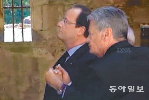 요아힘 가우크 독일 대통령(오른쪽)과 프랑수아 올랑드 프랑스 대통령이 2일 제2차 세계대전 중 독일 나치군이 대학살을 벌인 프랑스 중서부 도시 오라두르쉬르글란 마을을 찾았다. 두 정상이 생존자 로베르 에브라 씨와 함께
손을 잡고 교회를 둘러보고 있다. France3 화면 캡처
