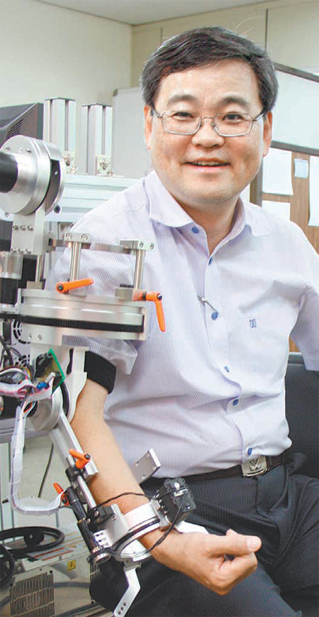 김성완 서울대 의공학과 교수가 자신이 개발한 팔이 불편한 사람을 위한 재활로봇을 움직여보고 있다.