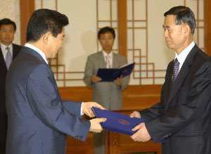 2006년 8월 노무현 대통령이 이선희 방위사업청장에게 임명장을 주고 있다.