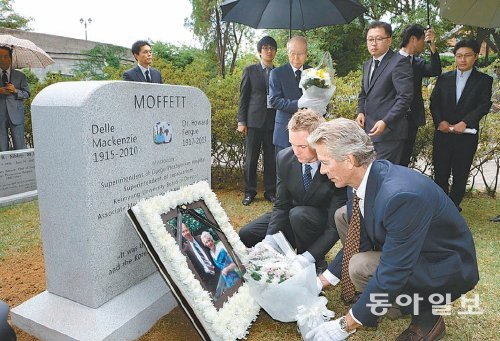 25일 계명대 동산의료원 은혜정원에서 열린 의료선교사 하워드 모펫 부부 유해 안장식에서 막내아들 샘 모펫 씨(오른쪽)와 외손자 이언 테일러 씨가 묘비에 헌화하고 있다. 계명대 동산의료원 제공