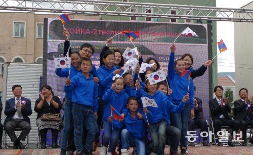 지난달 4일 몽골 울란바토르 시에서 열린 한국지역난방공사의 어린이도서관 개관 기념식에서 몽골 어린이들이 태극기와 몽골 국기를 흔들며 공연을 하고 있다. 한국지역난방공사 제공