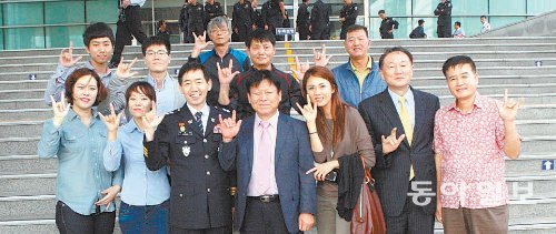 2일 대전지방경찰청 무궁화홀 앞에서 수화경연대회를 마친 뒤 정용선 대전지방경찰청장(앞줄 왼쪽에서 세 번째)과 지교하 대전농아인협회장(정 청장 오른쪽) 등 농아인협회 관계자들이 ‘사랑합니다’라는 의미의 수화를 하며 기념촬영을 했다. 대전지방경찰청 제공