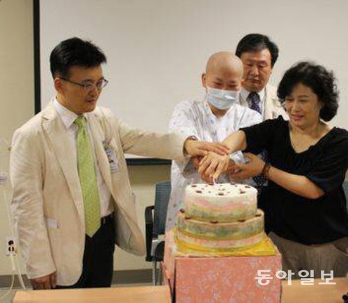 5000번째 조혈모세포 이식환자인 곽지원 양(왼쪽에서 두 번째)이 의료진과 함께 케이크를 자르며 퇴원을 자축하고 있다. 서울성모병원 제공